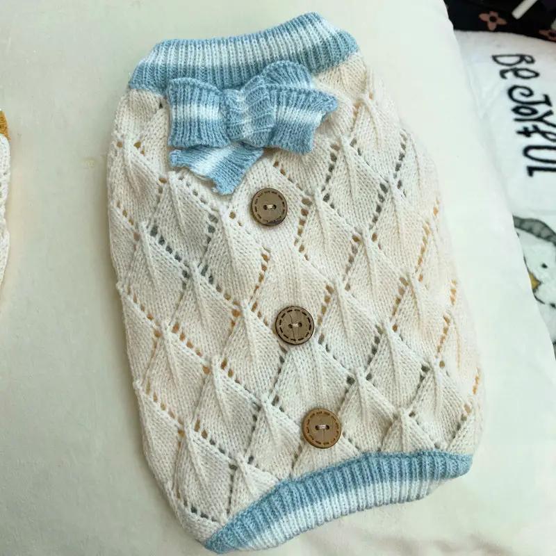 Knitted dog sweater by Pet Zen in cream with blue ribbed collar and bow, buttoned front