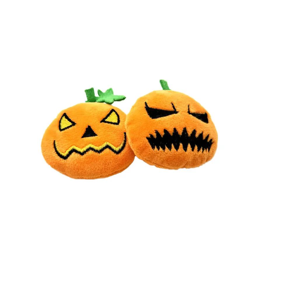 Pair of orange plush pumpkin cat toys with ghost faces