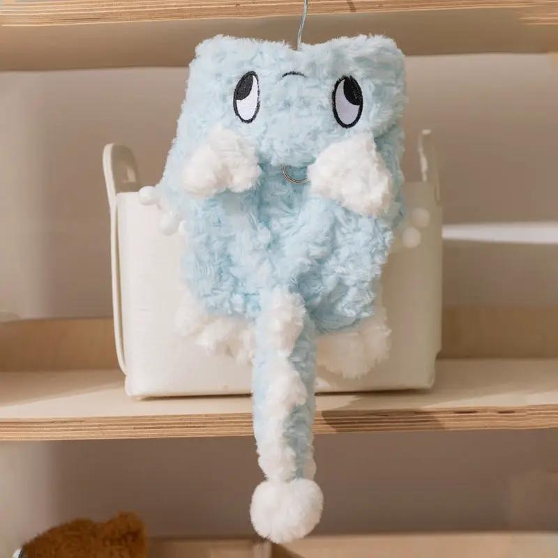 Blue plush dinosaur toy with white fluffy accents and a long dangling leg on a shelf.
