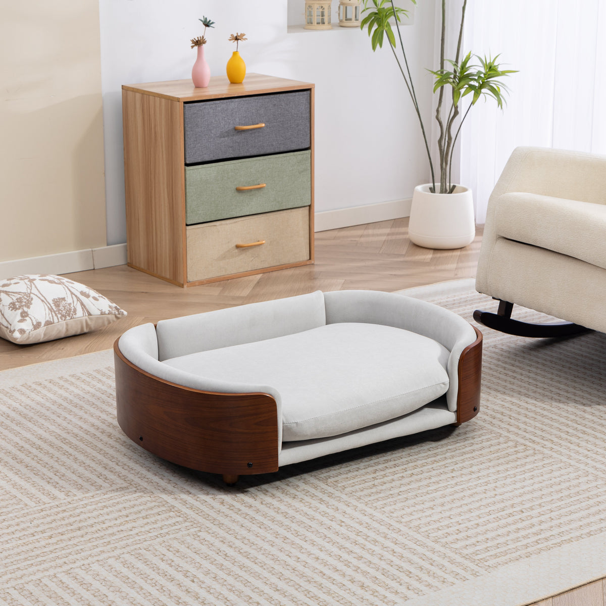 Scandinavian style elevated dog bed with solid wood legs and light gray cushion in a modern living room.
