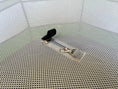 Load image into Gallery viewer, Hen Pen Deluxe Pop-Up Chick Brooder on a perforated metal surface with a black strap and metal clips
