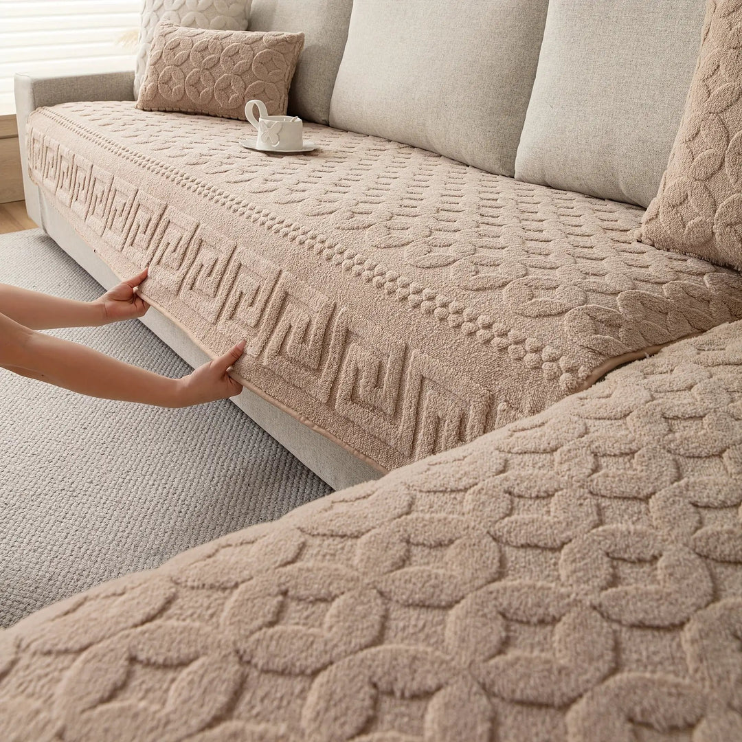 L-shaped couch cover in beige fabric being fitted over a sofa