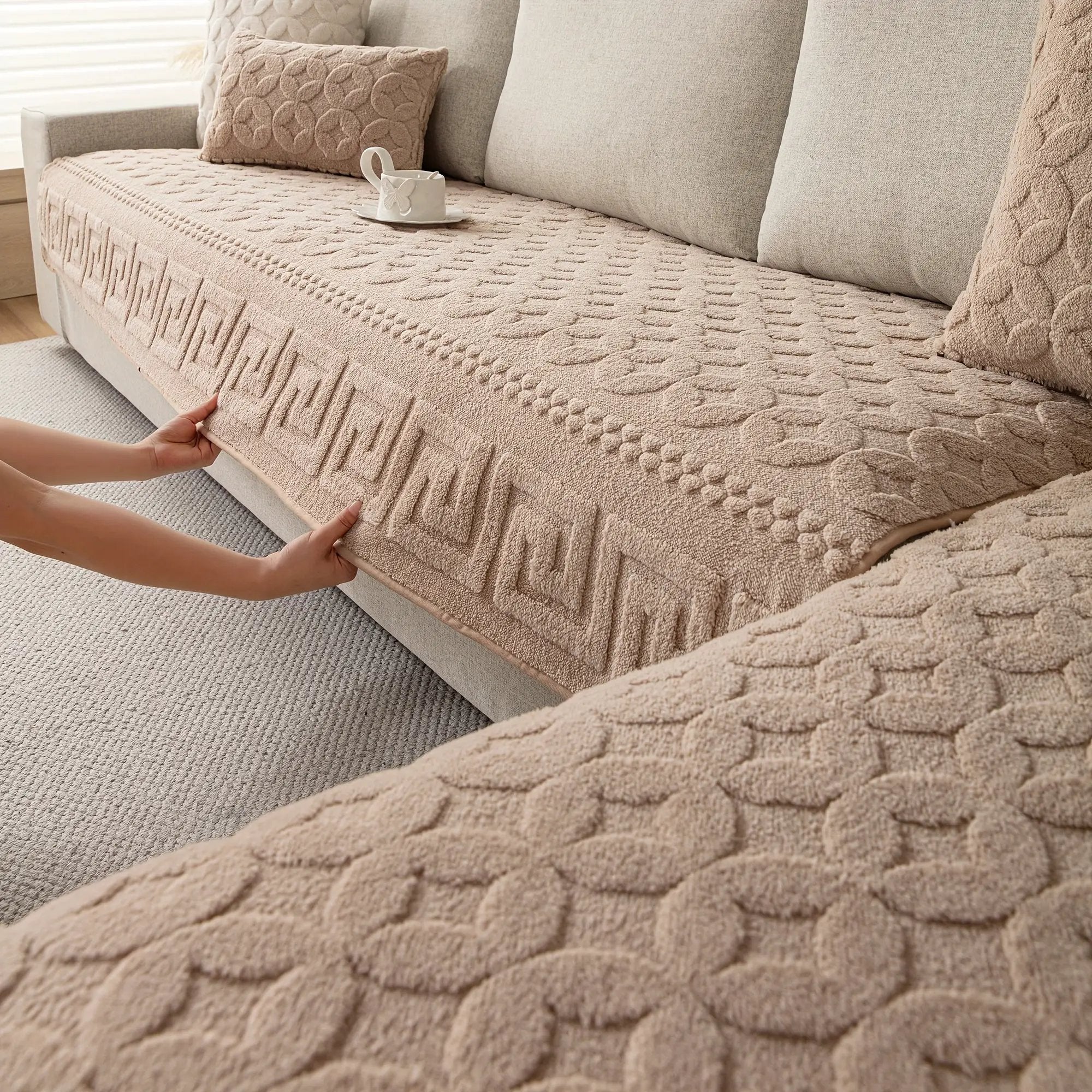 L-shaped couch cover in beige fabric being fitted over a sofa