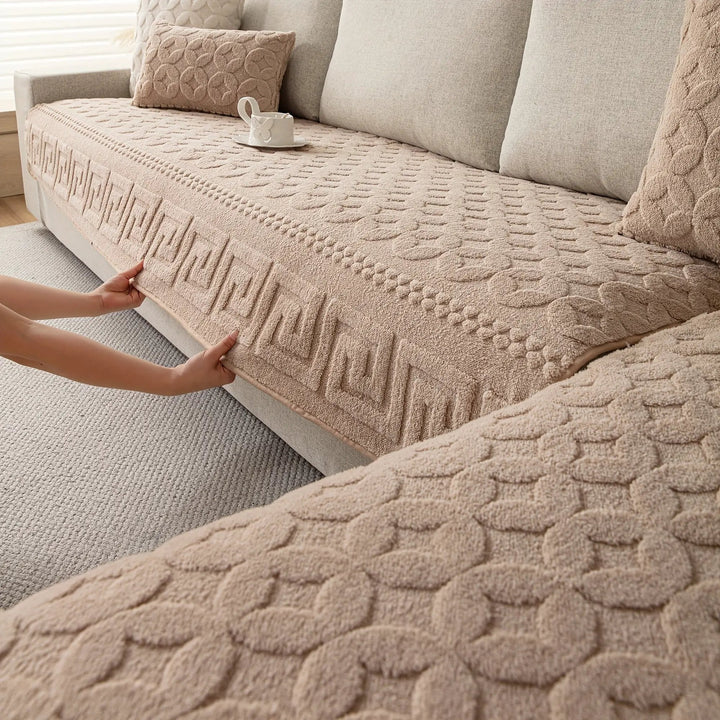 L-shaped couch cover in beige fabric being fitted over a sofa
