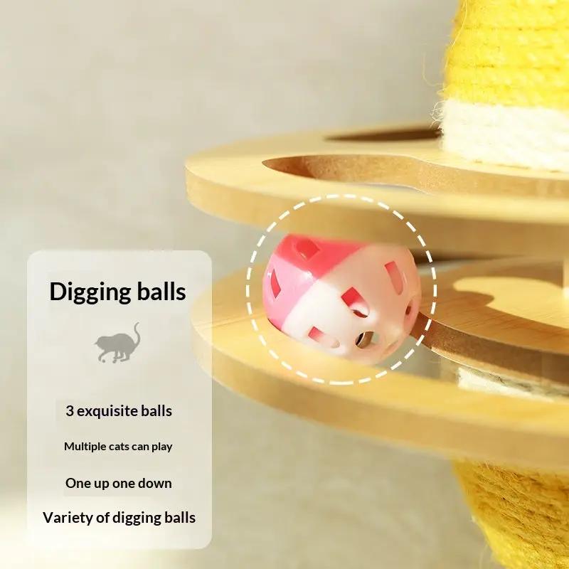 Cat digging ball toy, pink and white perforated plastic sphere on a wooden multi-level scratching post