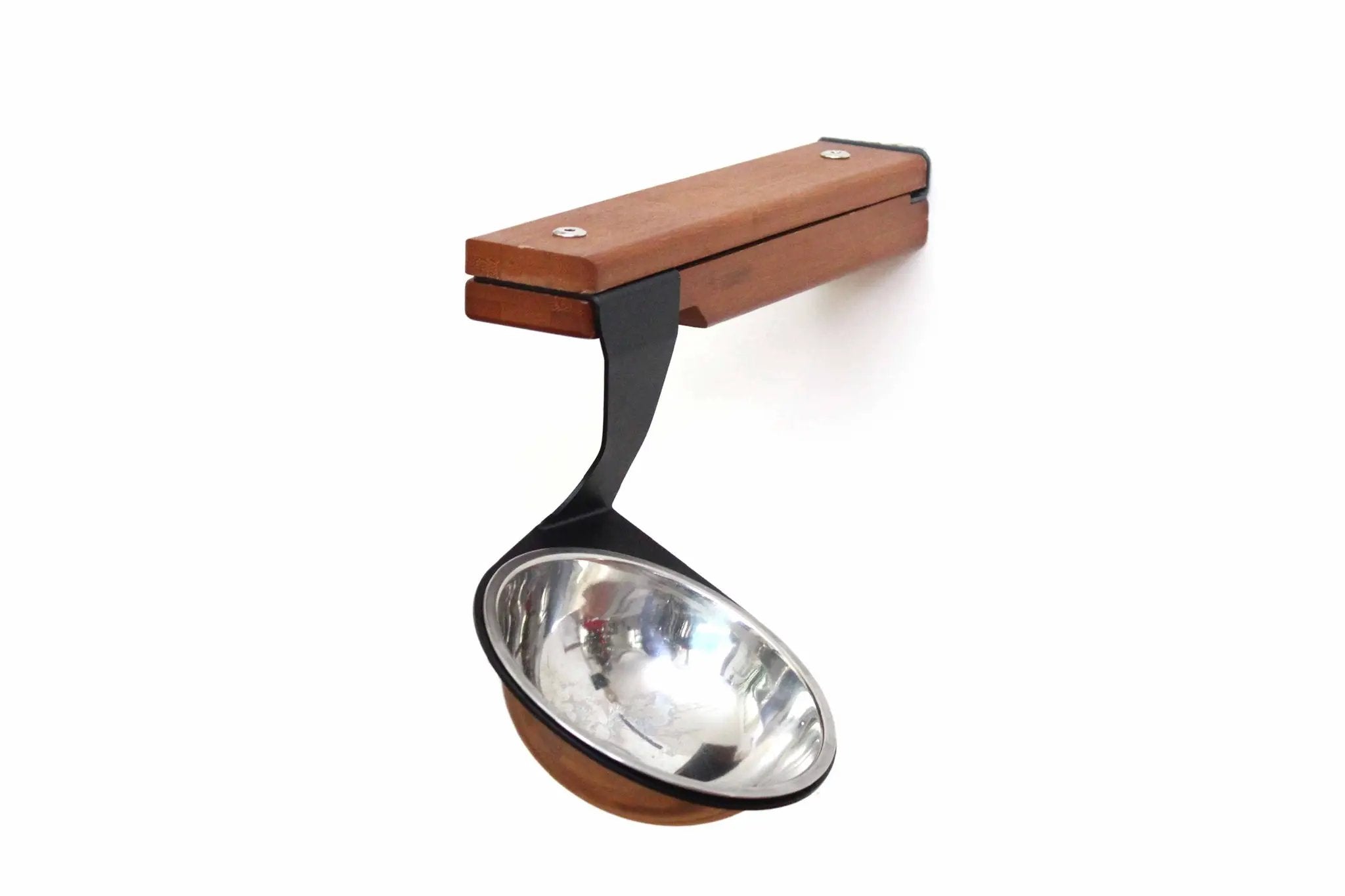 Wall-mounted cat feeding shelf with brown wooden block and metal bowl on a black arm.