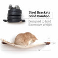 Load image into Gallery viewer, Hanging Cat Bed Hammock by Catastrophic Creations on a wooden platform with steel brackets; orange tabby cat resting.
