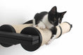 Carica l'immagine nel visualizzatore della galleria, Horizontal cat scratcher with beige sisal surface and black end caps; kitten perched on it.
