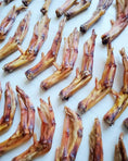 Load image into Gallery viewer, Dried duck feet laid out on a white background; brown-yellow, wrinkled feet with a leathery texture.
