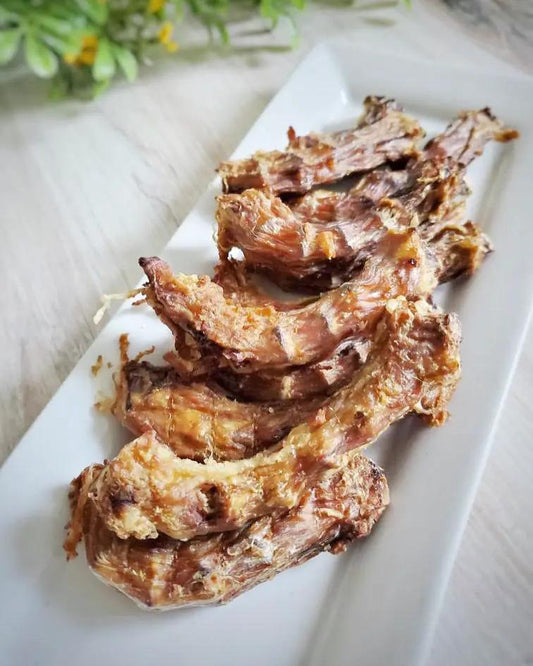 Naked Beasts chicken necks, bone-in and crispy roasted, on a white rectangular platter (5 pieces)
