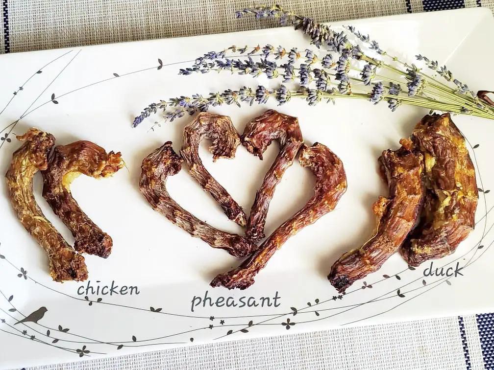Chicken necks on a white plate with lavender sprigs; several dried neck pieces