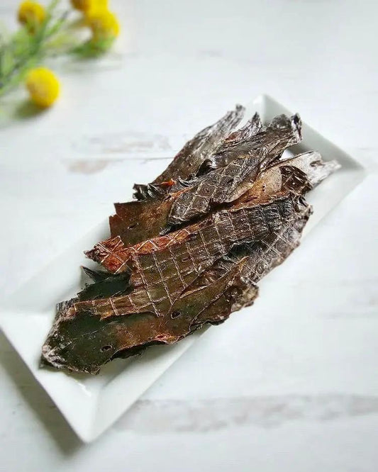 Pork Liver Thin Cut by Naked Beasts; dark brown dried slices on a white plate