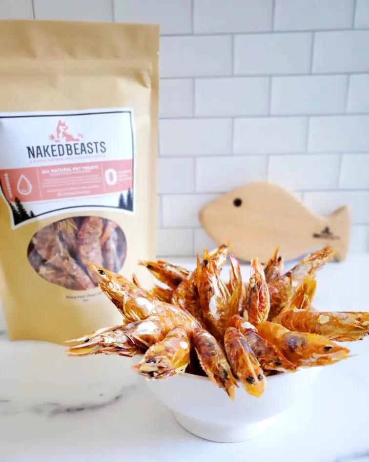 Shrimp treats from Naked Beasts in a white bowl, with a Naked Beasts bag in the background