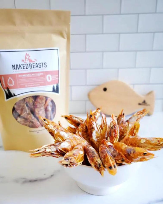 Shrimp treats from Naked Beasts in a white bowl, with a Naked Beasts bag in the background
