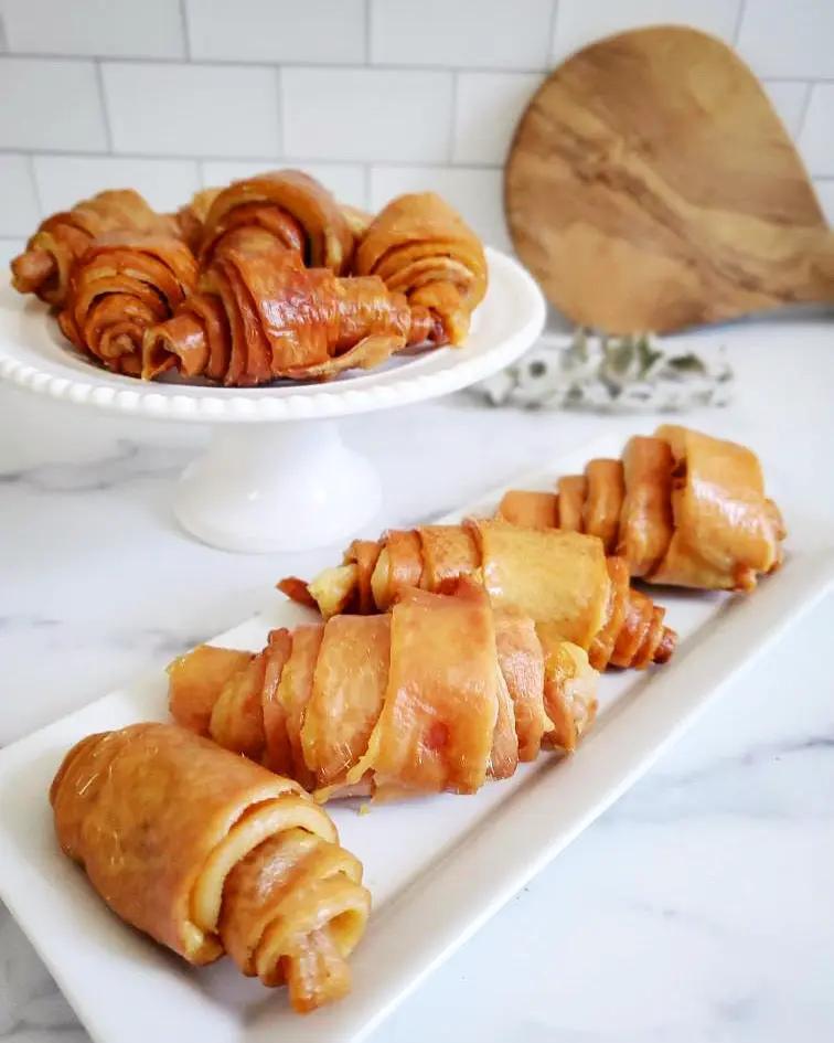 Pork Skin Rolls by Naked Beasts on a white platter; golden-brown spiral rolls.