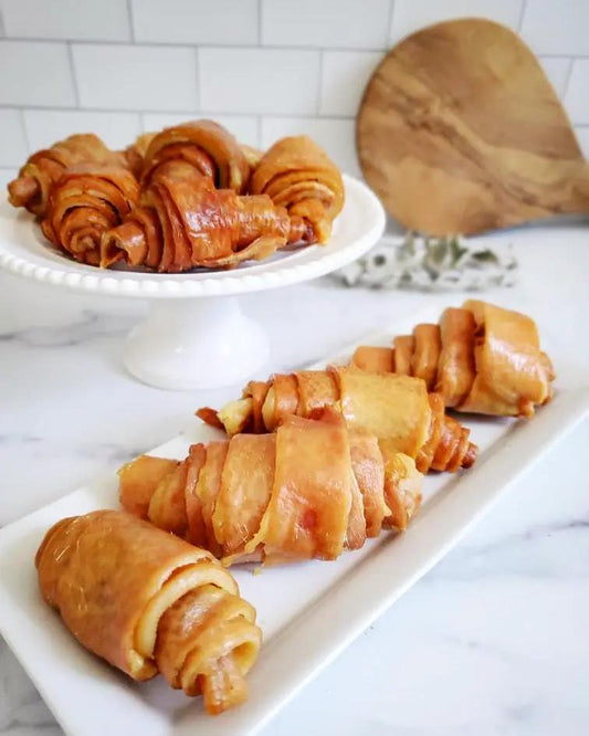Pork Skin Rolls by Naked Beasts on a white platter; golden-brown spiral rolls.