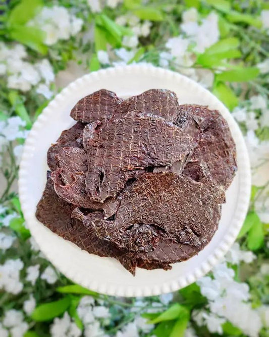 Lamb Liver Thin Cut by Naked Beasts, several dark brown slices on a white plate.
