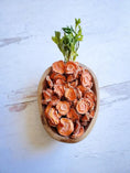 Load image into Gallery viewer, Carrots by Naked Beasts: orange dried carrot slices in a wooden bowl with green stems.

