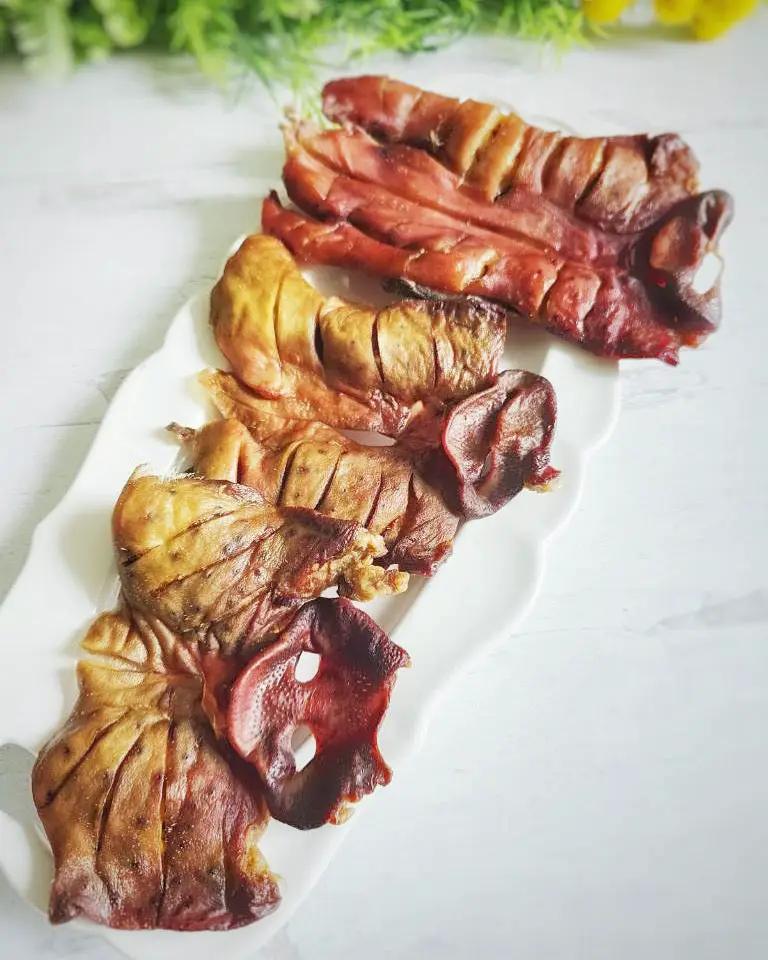 Pig Snout Naked Beasts: sliced, brownish-red pig snout pieces on a white plate