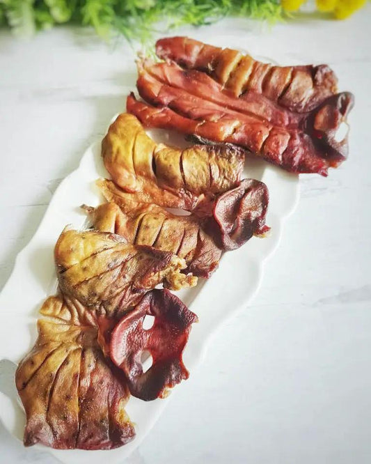 Pig Snout Naked Beasts: sliced, brownish-red pig snout pieces on a white plate