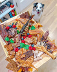 Load image into Gallery viewer, Naked Beasts Whole Quails (Bone-In) dog treats on a wooden board, showing assorted dried meat pieces
