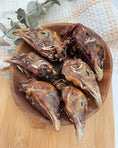 Carica l'immagine nel visualizzatore della galleria, Pheasant Heads by Naked Beasts, roasted game heads in a brown bowl with eucalyptus sprigs.
