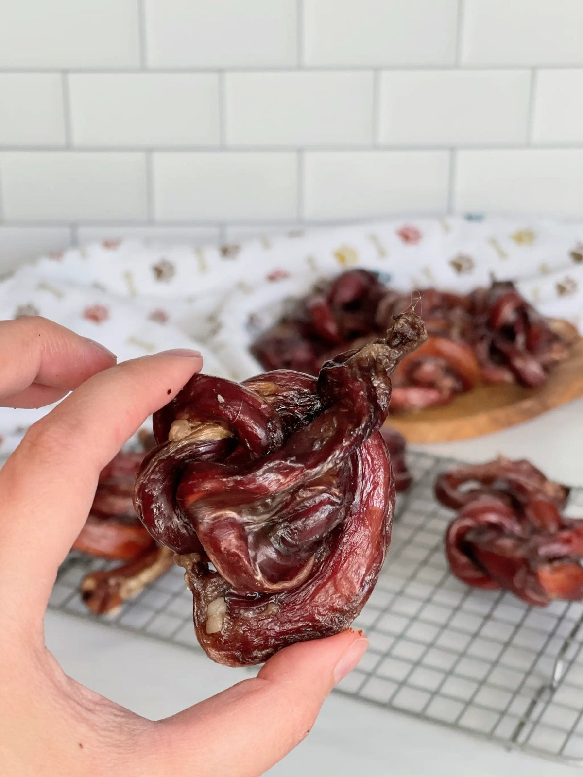 Beef Pizzle loops, dried dark red chews; twisted coils on rack