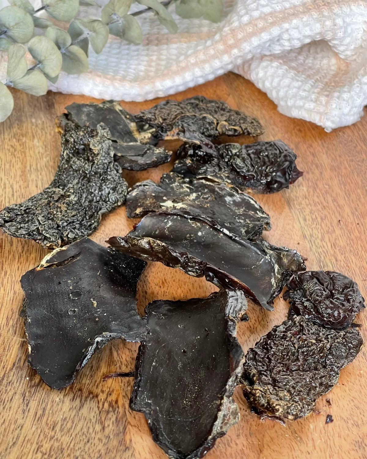 Duck Livers (ABF) from Naked Beasts; dark, dried chunks, multiple pieces on a wooden board