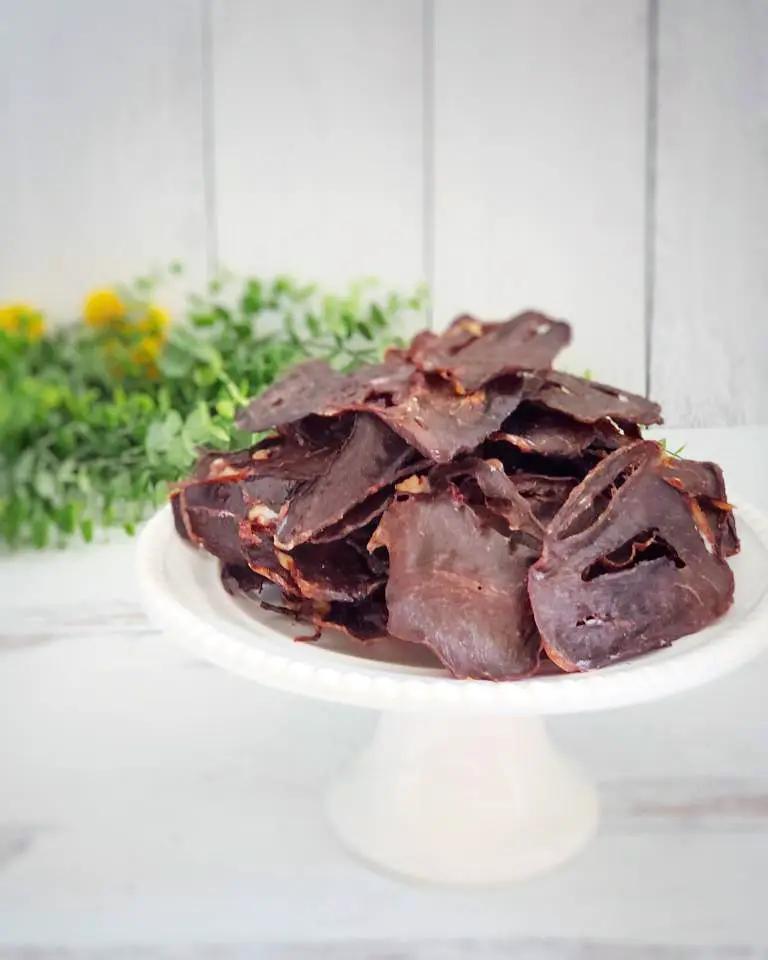 Lamb Heart (Fat Trimmed) Thin Cut jerky by Naked Beasts on a white pedestal plate