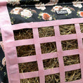 Load image into Gallery viewer, Jeffers Expression Extend-Feed Hay Bag in pink lattice with floral-patterned exterior and hay inside; brand tag visible.

