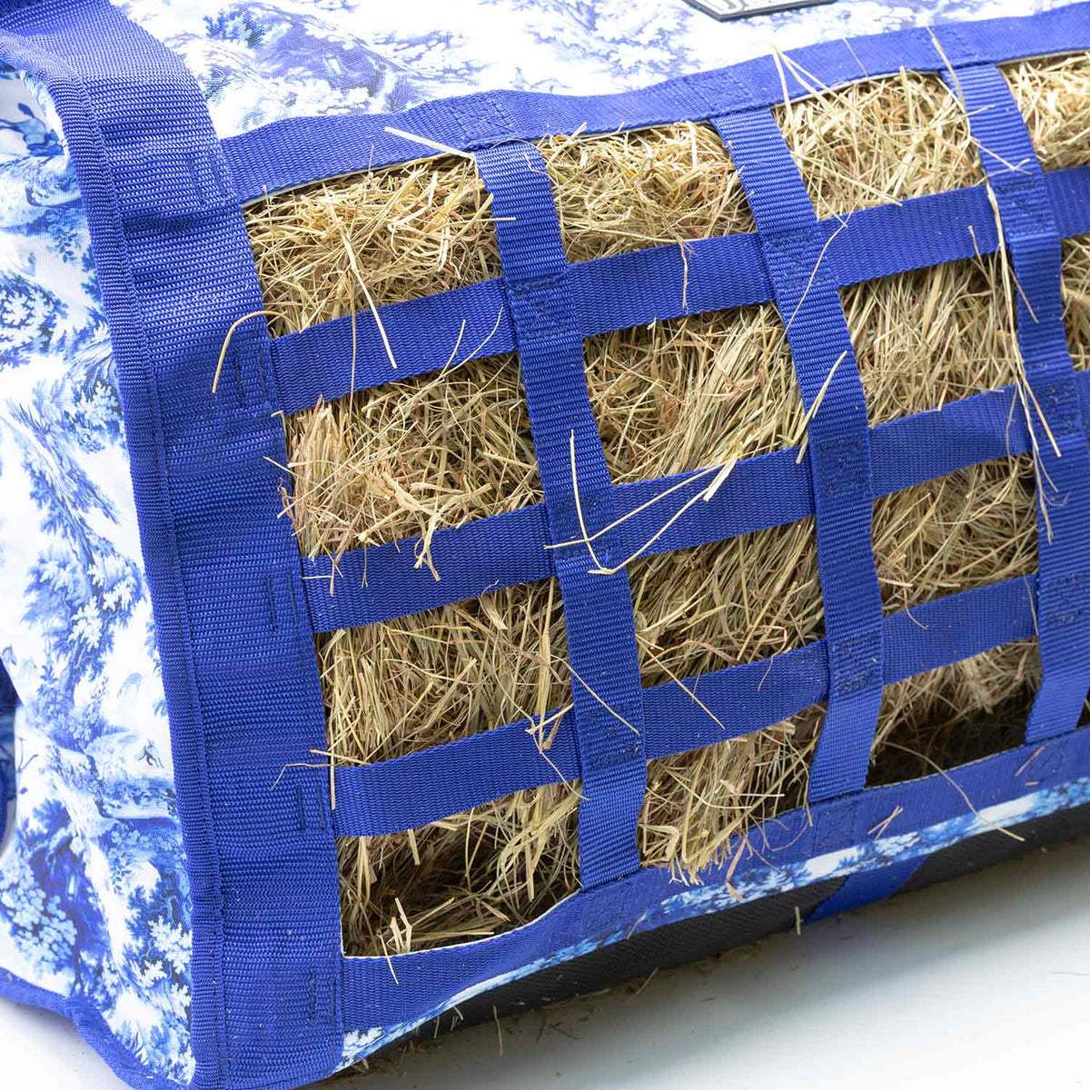 Jeffers Expression Extend-Feed hay bag, blue webbing grid filled with hay.