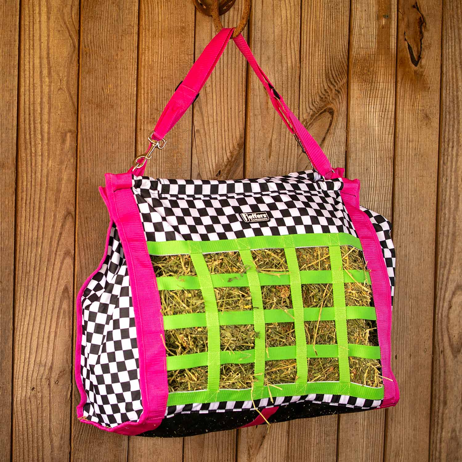 Jeffers Expression Extend-Feed hay bag for livestock, pink straps, black-and-white checker fabric with green hay grid.