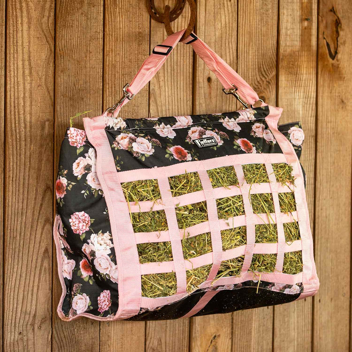 Jeffers Expression Extend-Feed Hay Bag for Horses & Livestock with pink straps and floral black fabric showing hay mesh.