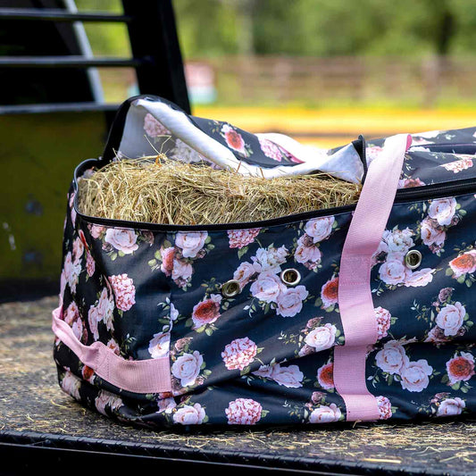Jeffers Expression Full Hay Bale Tote Bag, floral navy fabric with pink handles, filled with hay.