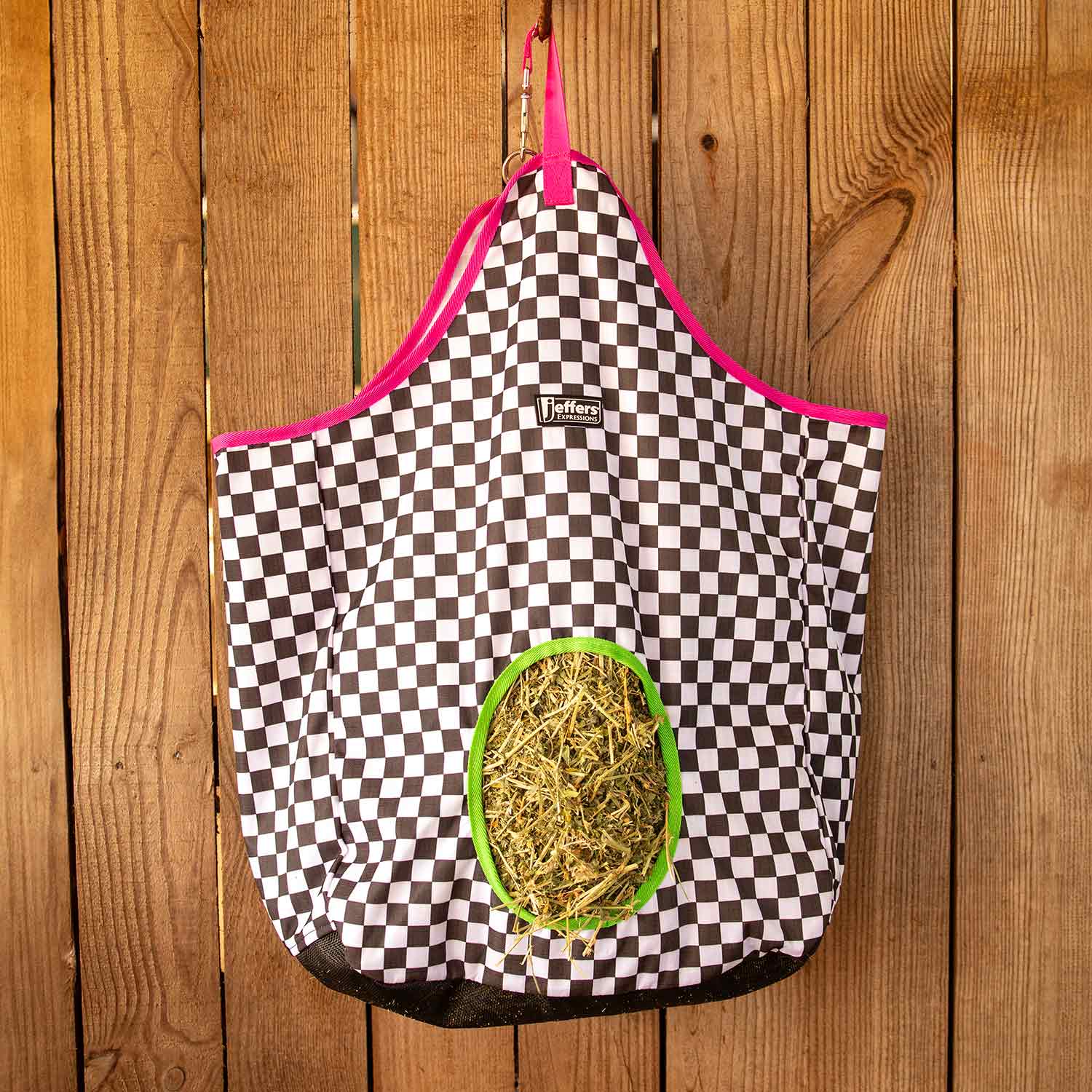 Jeffers Expression Top Loading Hay Bag, 600 Denier; black-and-white checker fabric with pink trim and green opening.