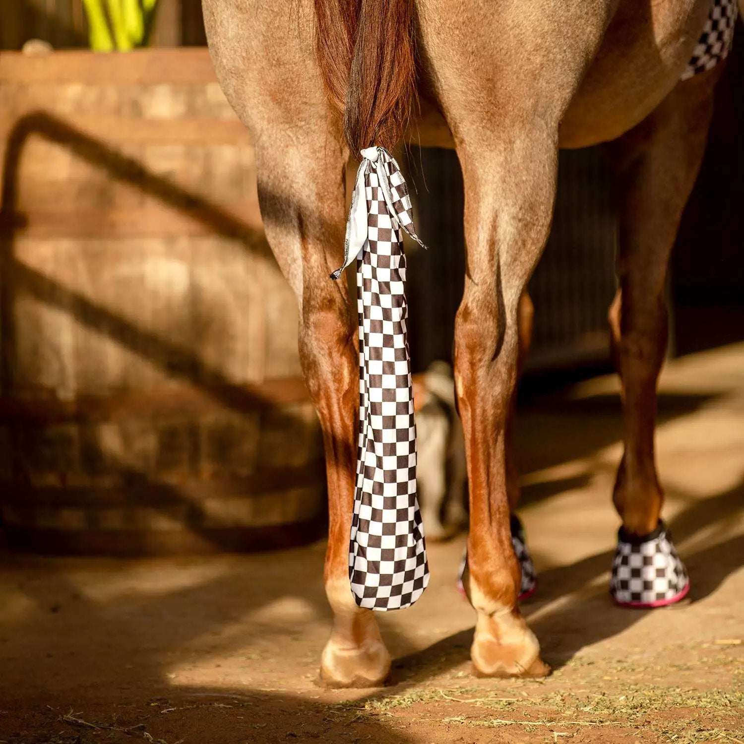 Lycra horse tail bag, 24 inches long, black and white checkered pattern; shown on a horse with two matching leg wraps.