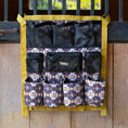 Load image into Gallery viewer, Jeffers Expression trailer-door horse grooming caddy with yellow straps and multiple black and patterned pockets
