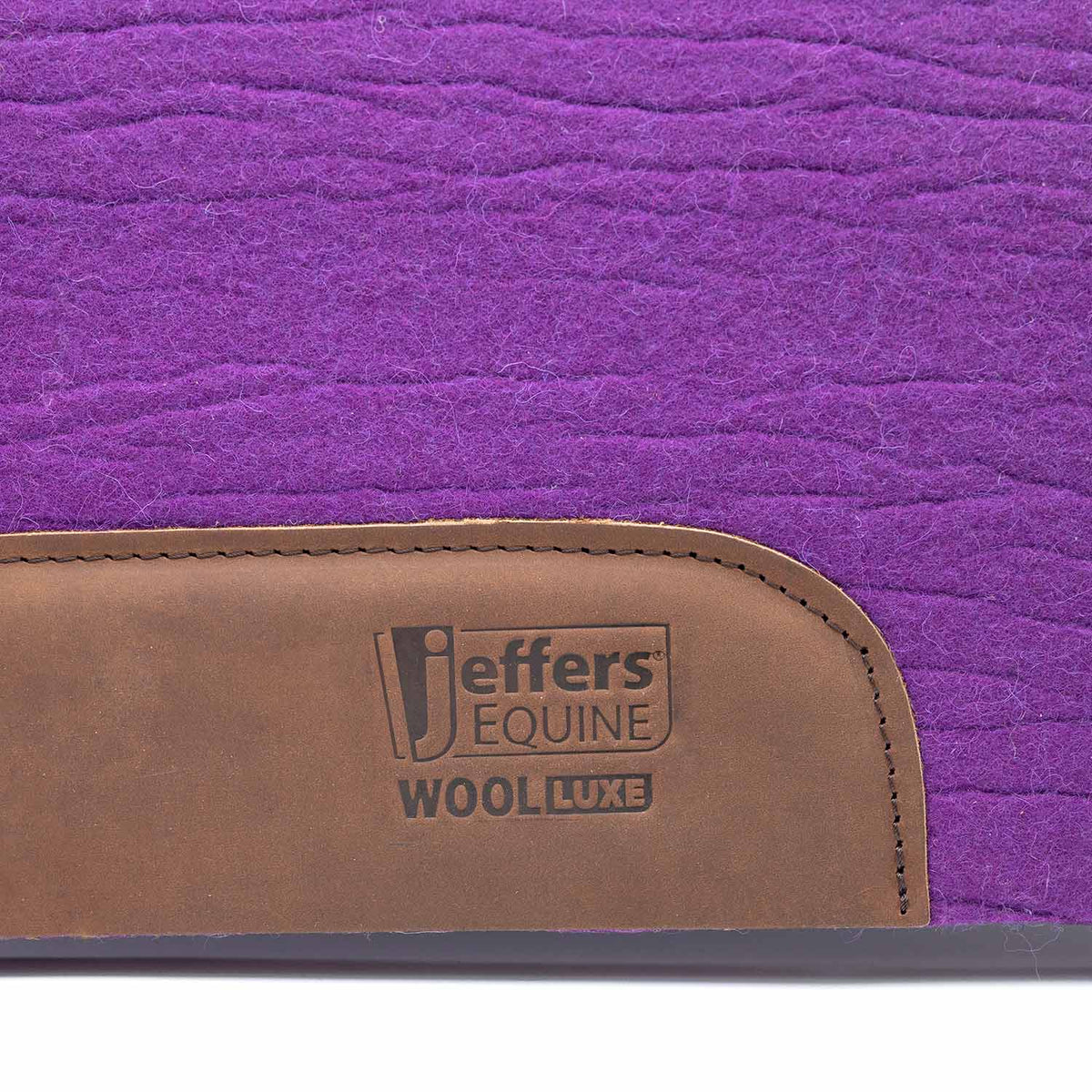 Jeffers WoolLuxe saddle pad, 100% wool, purple quilted pad with brown leather patch bearing the Jeffers Equine logo
