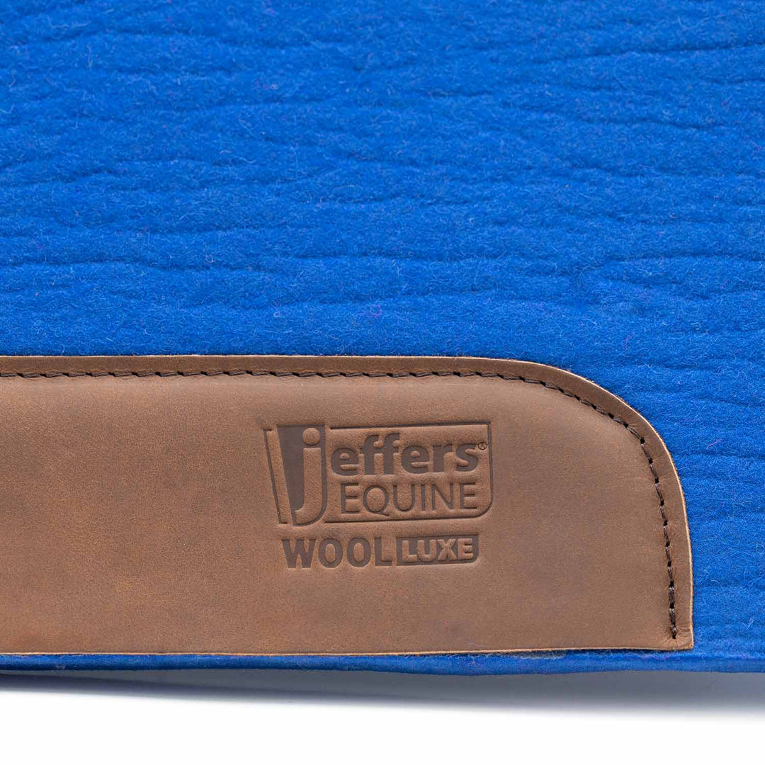 Jeffers WoolLuxe saddle pad in blue with a brown leather patch embossed Jeffers Equine Wool Luxe