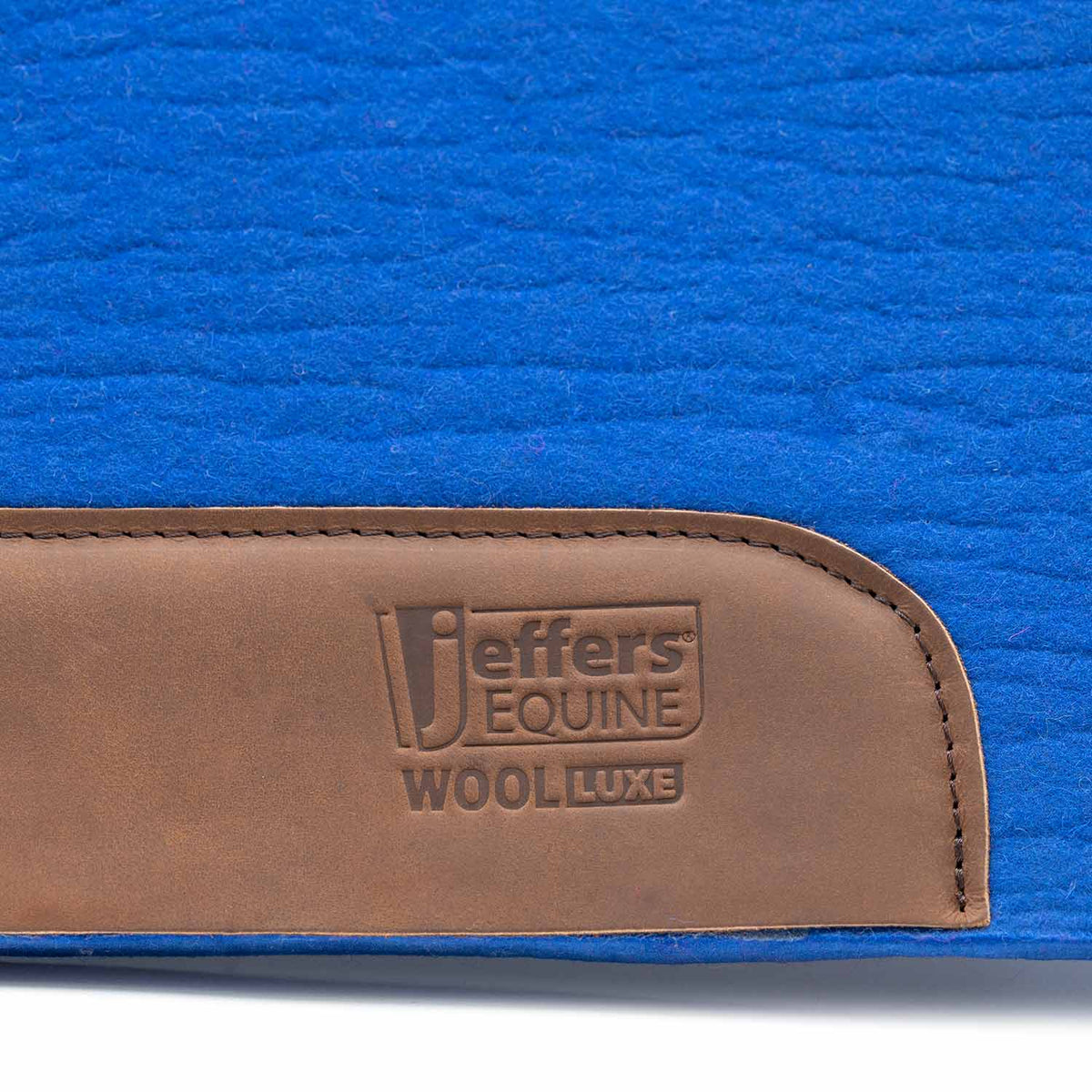 Jeffers WoolLuxe saddle pad in blue with a brown leather patch embossed Jeffers Equine Wool Luxe