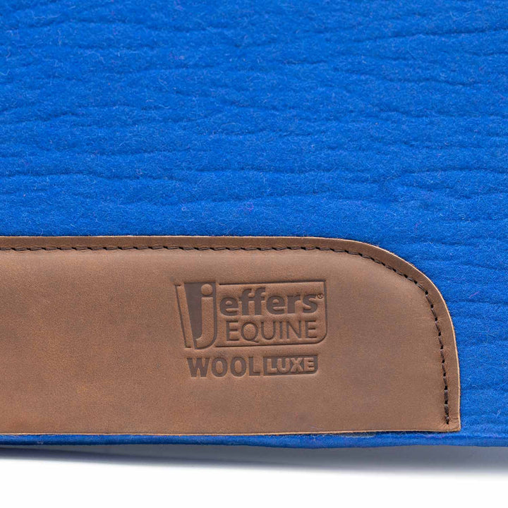 Jeffers WoolLuxe saddle pad in blue with a brown leather patch embossed Jeffers Equine Wool Luxe