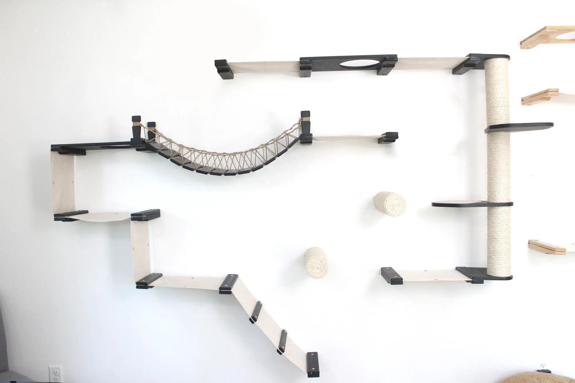 The Juggernaut wall-mounted cat condo by Catastrophic Creations featuring platforms, rope bridge, and sisal post.
