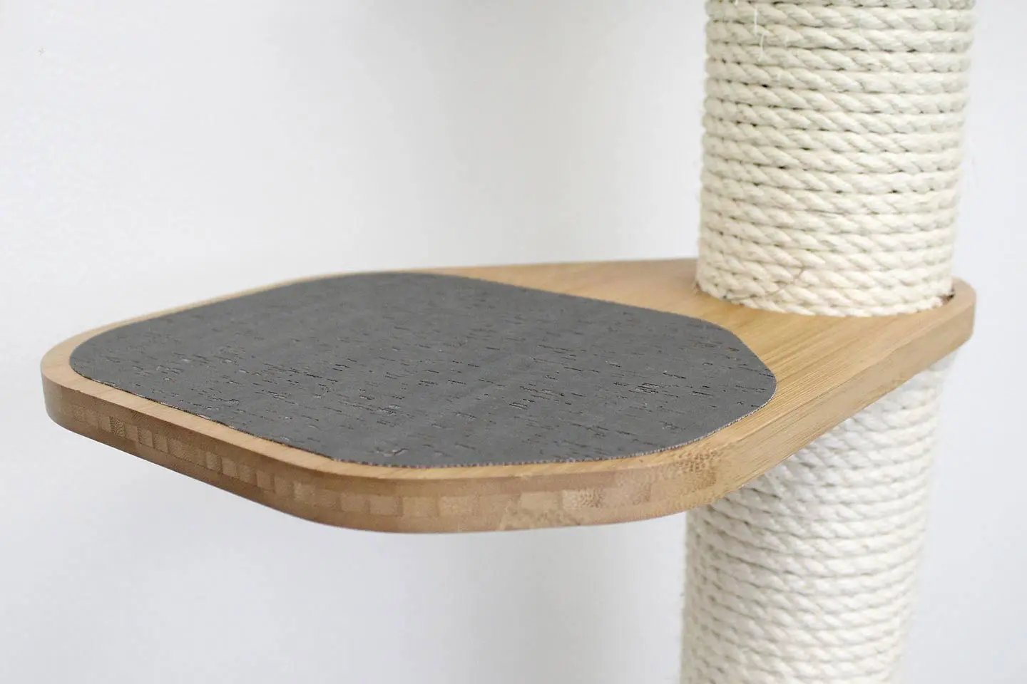 The Climb Condo cat wall climbing system; wooden platform with gray circular scratch pad and rope-wrapped post