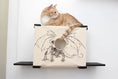 Carica l'immagine nel visualizzatore della galleria, Cat Cubby for Wall - Covered Cat Bed by Catastrophic Creations; beige fabric cubby with dragon graphic and round hole.
