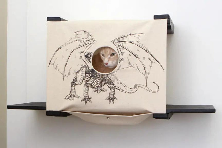 Cat Cubby for Wall covered cat bed by Catastrophic Creations; beige fabric cube with dragon art and entry hole