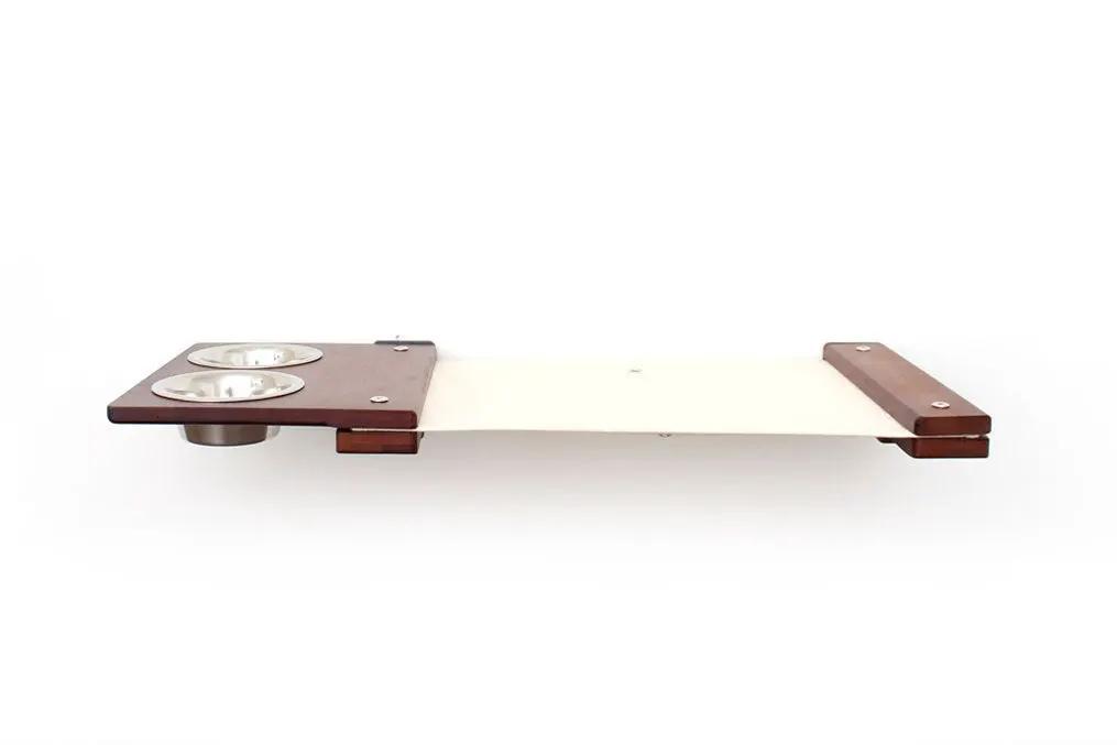 Catastrophic Creations cat hammock feeder, wall-mounted raised platform with wood ends and dual metal bowls.