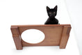 Load image into Gallery viewer, Wall Mounted Cat Shelf by Catastrophic Creations; wooden brown finish with a black kitten perched.
