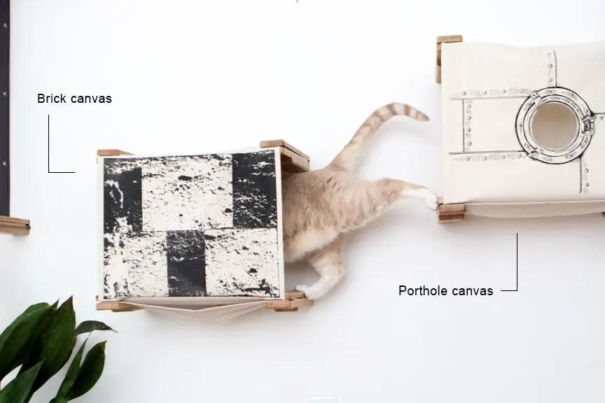 Enclosed Cat Bed Cat Wall Cubby by Catastrophic Creations; brick canvas cube and porthole canvas cube with a cat.