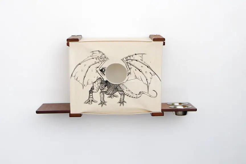 Deluxe Cat Cubby Bed by Catastrophic Creations; beige fabric cubby with dragon print and round entrance on shelves.