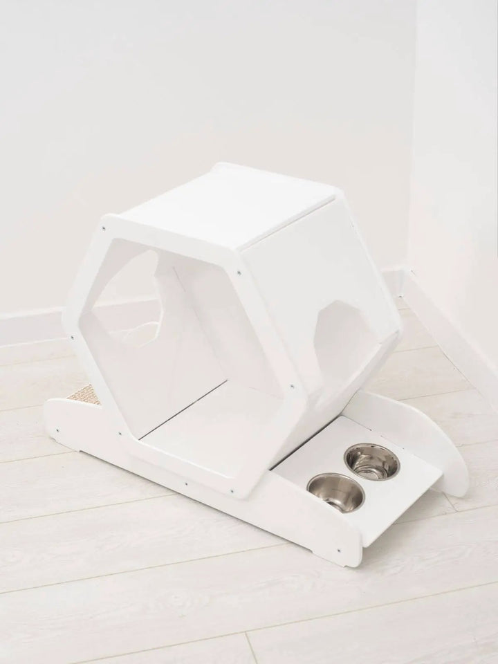 Small white wooden cat house with built-in dual metal bowls.
